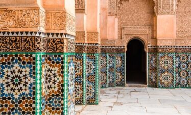 Traditional Moroccan doorway with intricate mosaic tiles and a carved wooden door