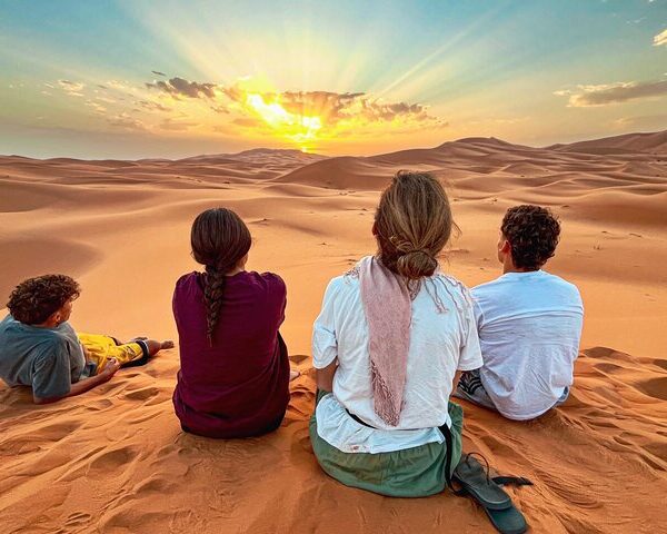 People watching the sunrise over the golden dunes of Erg Chebbi, Sahara Desert, Morocco