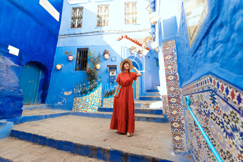 Narrow blue-painted street in Chefchaouen, Morocco, with local artisan shops