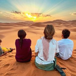 People watching the sunrise over the golden dunes of Erg Chebbi, Sahara Desert, Morocco